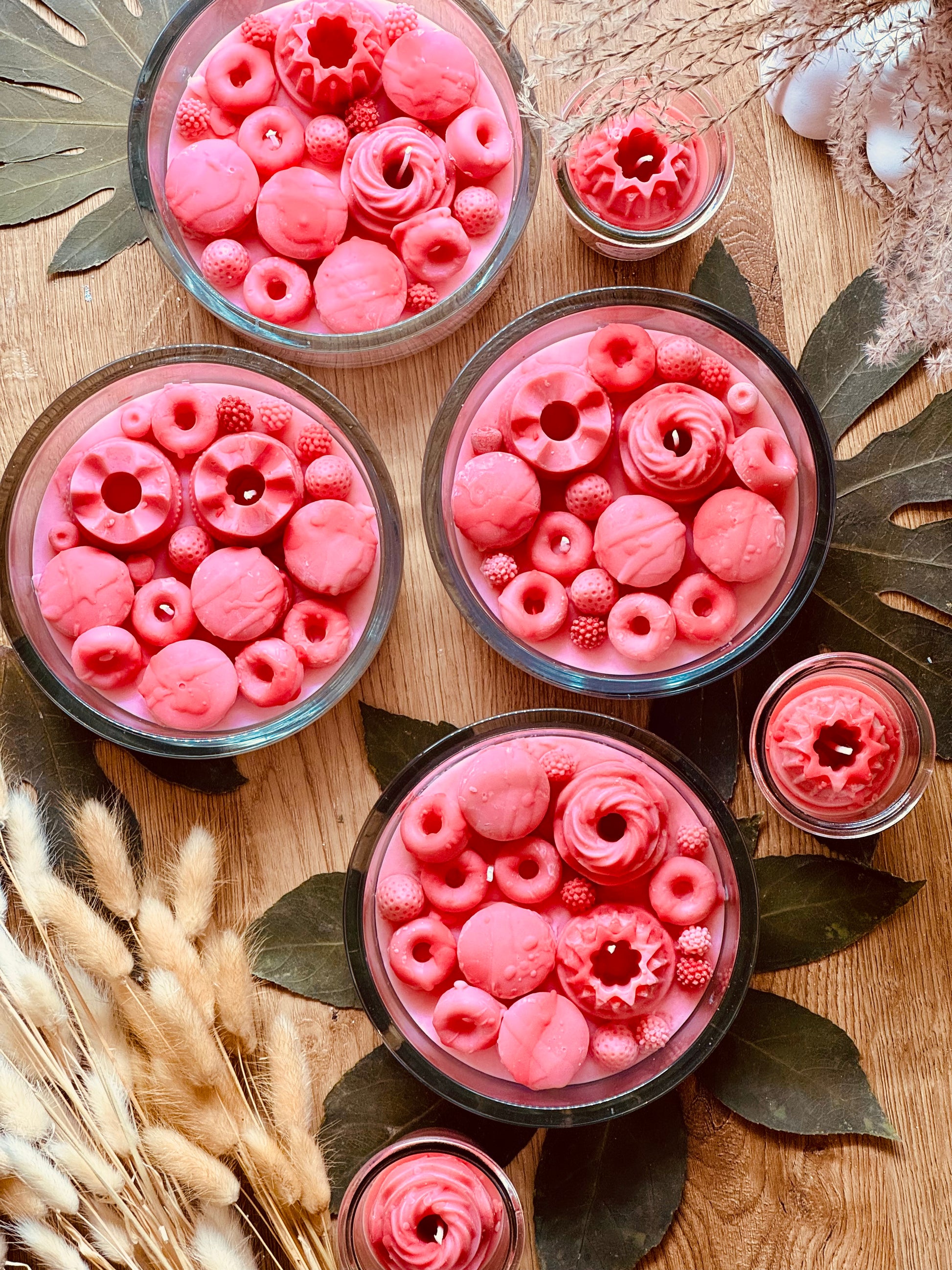 Duftkerze im Glas in zartem Rosa und Pink mit verspielter Verzierung aus Wachssüßigkeiten – ein originelles Geschenk und duftende Deko