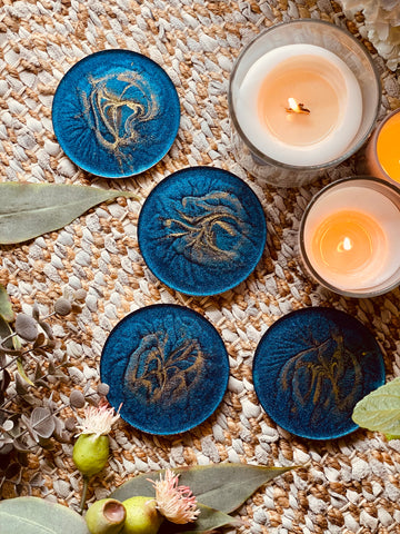 4 resin coasters in blue with gold